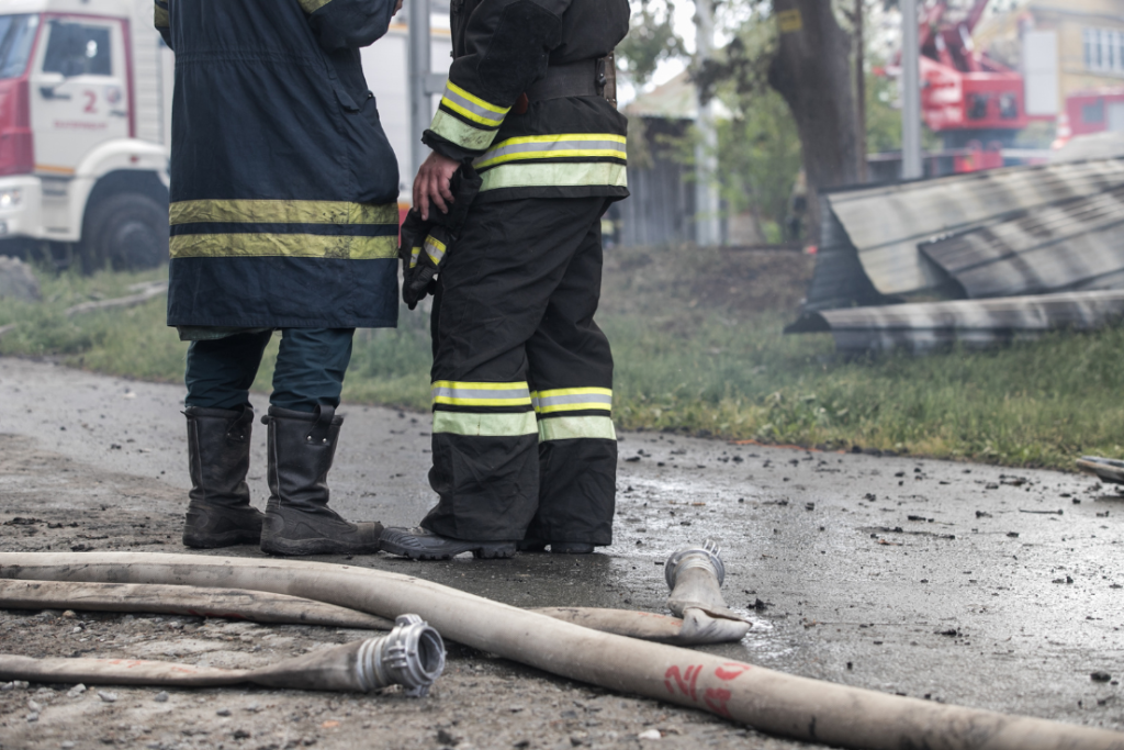 Two firefighters standing around after a disaster because a building hasn't been outsourced to CAD Redraw yet